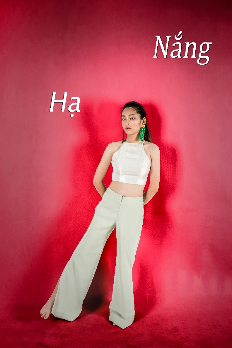 Cover photo for Ha Nang project. Model is shown wearing one of the project's clothing pieces against a vibrant red background.